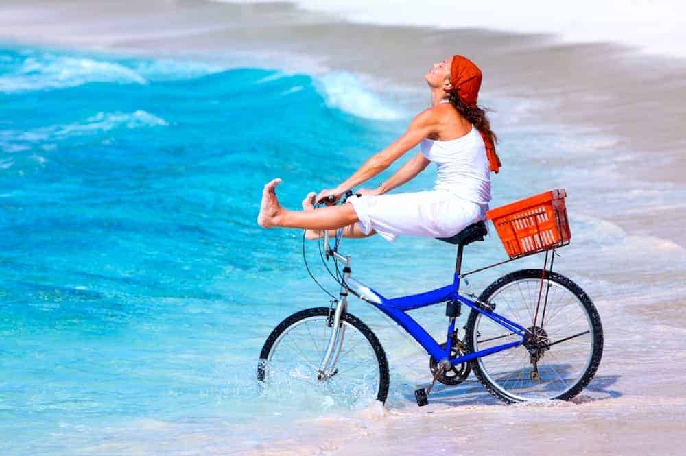 Frau fährt mit Fahrrad ins Meer - Lebenszahl 3