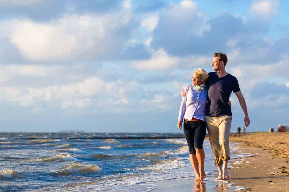 Paar geht am Strand entlang - Partnerschaft