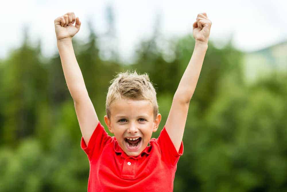 Lebenszahl 8 Kinder: Junge streckt Hände in die Höhe