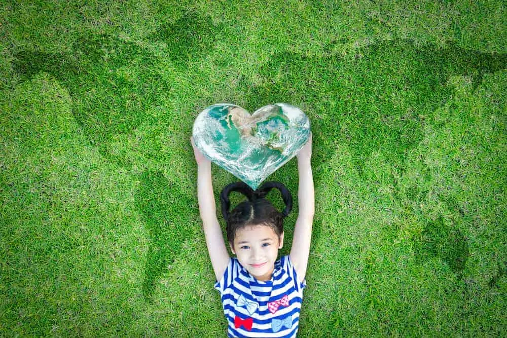 Lebenszahl 9 Kinder: Mädchen streckt Hände mit Herz nach oben