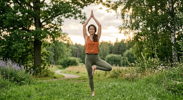 Frau praktiziert Vrikshasana (Baumhaltung) – Yoga-Übung für Lebenszahl 4 zur Stärkung von Erdung und Stabilität